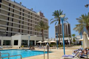 a resort with a pool and palm trees and buildings at Golden Tulip Bahrain in Manama