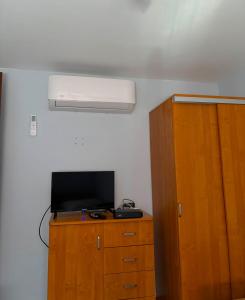 a bedroom with a tv and a wooden cabinet at Noclegi nad Zaporą in Międzybrodzie Bialskie +7 photos