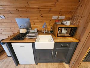 a small kitchen with a sink and a stove at Mountain Edge Resort Mega pod 3 with Hot Tub in Church Stretton