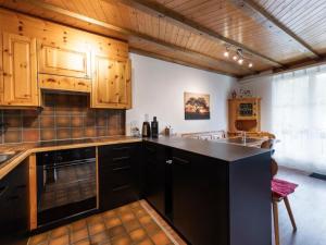 a kitchen with wooden cabinets and a black counter top at Apartment Wohnung Wettstein by Interhome in Sörenberg
