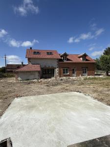 a house is under construction with a large concrete pad in front at La Grange aux Etangs - Le Gîte in Sennely