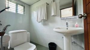 a white bathroom with a toilet and a sink at Neelima Resort in Cox's Bazar +41 photos