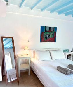 a bedroom with a bed and a table with a mirror at Lilly's seaview Apartment in Mikonos