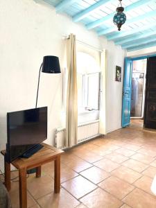 a living room with a tv and a table at Lilly's seaview Apartment in Mikonos