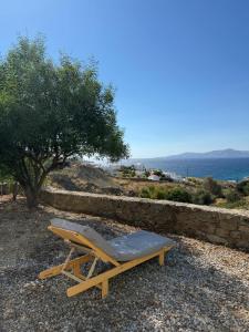 a lounge chair sitting on top of a stone wall at Lilly's seaview Apartment in Mikonos