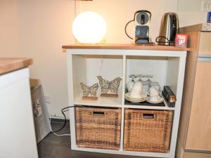 a kitchen cabinet with wicker baskets and utensils at Apartment Neuheim by Interhome in Neuheim