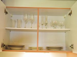 a cabinet filled with glasses and plates on shelves at Apartment Neuheim by Interhome in Neuheim