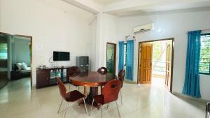 a dining room with a wooden table and chairs at Neelima Resort in Cox's Bazar