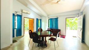a dining room with a wooden table and chairs at Neelima Resort in Cox's Bazar