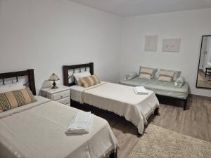 a bedroom with two beds and a bench in it at Casa Branco in Borba