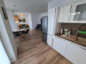 a kitchen with white cabinets and a dining table at Apartment Villa Brieselang in Brieselang