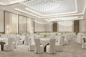 a banquet hall with white tables and white chairs at Element by Marriott Al Qassim in Buraydah +57 photos