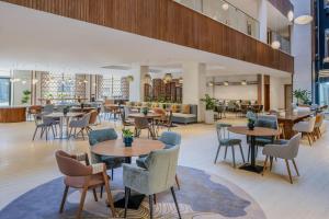 a restaurant with tables and chairs in a lobby at Element by Marriott Al Qassim in Buraydah