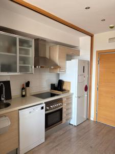 a kitchen with stainless steel appliances and a white refrigerator at Loft en Valencia in Burjassot +5 photos