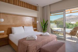 a bedroom with a bed with two towels on it at South Coast Hotel in Makry Gialos +47 photos