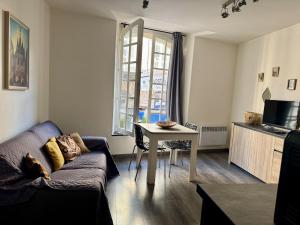 a living room with a couch and a table at Superbe appartement cosy Centre Bordeaux in Bordeaux
