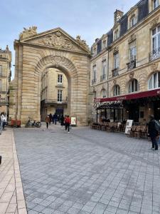 an entrance to a building with people walking in front at Superbe appartement cosy Centre Bordeaux in Bordeaux