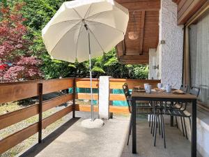 a table with an umbrella on a patio at Chalet Chalet Chaudoudoux - Les Paccots by Interhome in Les Paccots