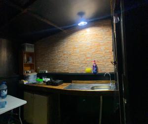 a kitchen with a sink and a brick wall at Kroom cabins in Bâne