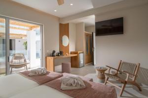 a bedroom with a bed with two towels on it at South Coast Hotel in Makry Gialos