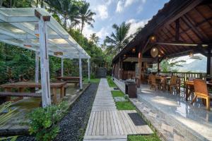 a patio of a restaurant with tables and benches at Medukuh Point Hill in Karangasem