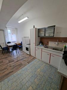 a kitchen with white cabinets and a table and chairs at Byt v okresu Děčin in Dolní Habartice