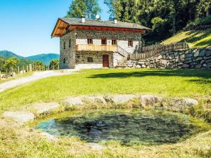 a stone house with a pond in front of it at by Interhome in Bedollo