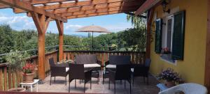 a deck with a table and chairs and an umbrella at Bed&Breakfast AmWeinberg in Gamlitz