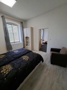 a bedroom with a bed and a couch and a window at Byt v okresu Děčin in Dolní Habartice +9 photos