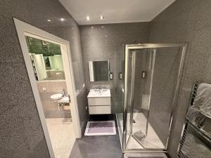 a bathroom with a shower and a sink and a mirror at Domus Hotel in Luxembourg +70 photos