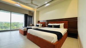 a bedroom with two beds and a large window at Hotel Inani Long Bay in Cox's Bazar +66 photos