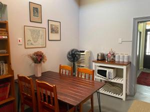 a dining room with a wooden table and chairs at Vlettershof Guest House in Robertson