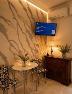 a room with a table and two chairs and a tv on a wall at Da Leo & Mia in Modena