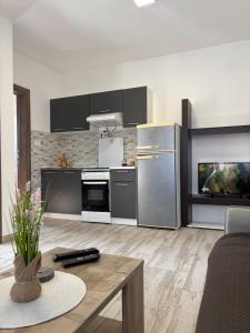 a kitchen with stainless steel appliances and a table at Lily Bloom Apartments in Radanovići
