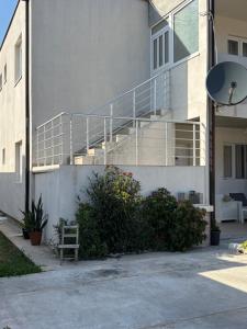 a white building with a staircase in front of it at Lily Bloom Apartments in Radanovići