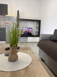 a living room with a couch and a vase with flowers at Lily Bloom Apartments in Radanovići +3 photos