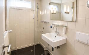 a white bathroom with a sink and a shower at DORMERO Hotel Essen in Essen +13 photos