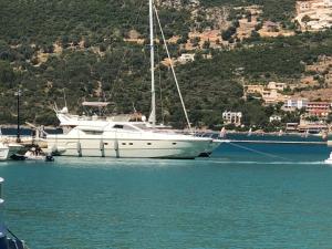 a boat is docked in the water next to a mountain at The Duke Superyacht - LINDIAN in Lindos