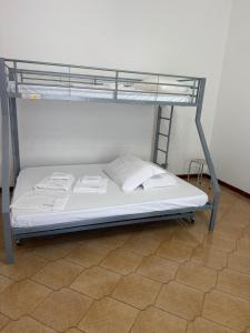 a bunk bed with white sheets and pillows on it at Il Rifugio della Grotta S.Ninfa in Santa Ninfa