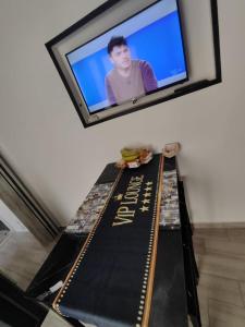 a television on a wall with a table with a sign at Magic House in Palermo