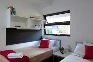 a small room with two beds and a window at Western Sydney University Village - Parramatta in Sydney