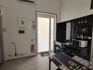 a kitchen with a door leading into a kitchen with a microwave at Magic House in Palermo