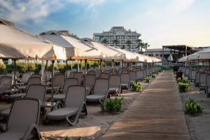 a row of chairs and umbrellas on a beach at Adalya Bliss in Side
