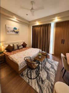 a hotel room with a bed and a table at The Skyline Studio in Greater Noida