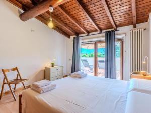 a bedroom with a large bed and a balcony at Apartment Legnone by Interhome in Sorico