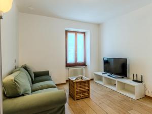 a living room with a couch and a flat screen tv at Apartment Legnone by Interhome in Sorico