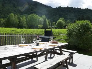 a picnic table with wine glasses and a grill at Apartment Apt- Terrace by Interhome in Olivone