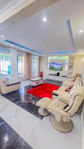 a living room with white furniture and a red rug at J&T Holme Villa in Galu
