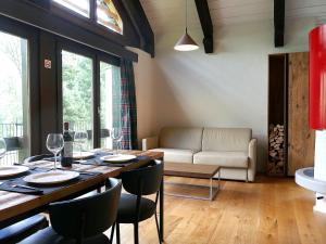 a dining room with a table and chairs and a couch at Apartment Apt- Terrace by Interhome in Olivone