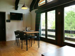 a dining room with a table and chairs and windows at Apartment Apt- Terrace by Interhome in Olivone